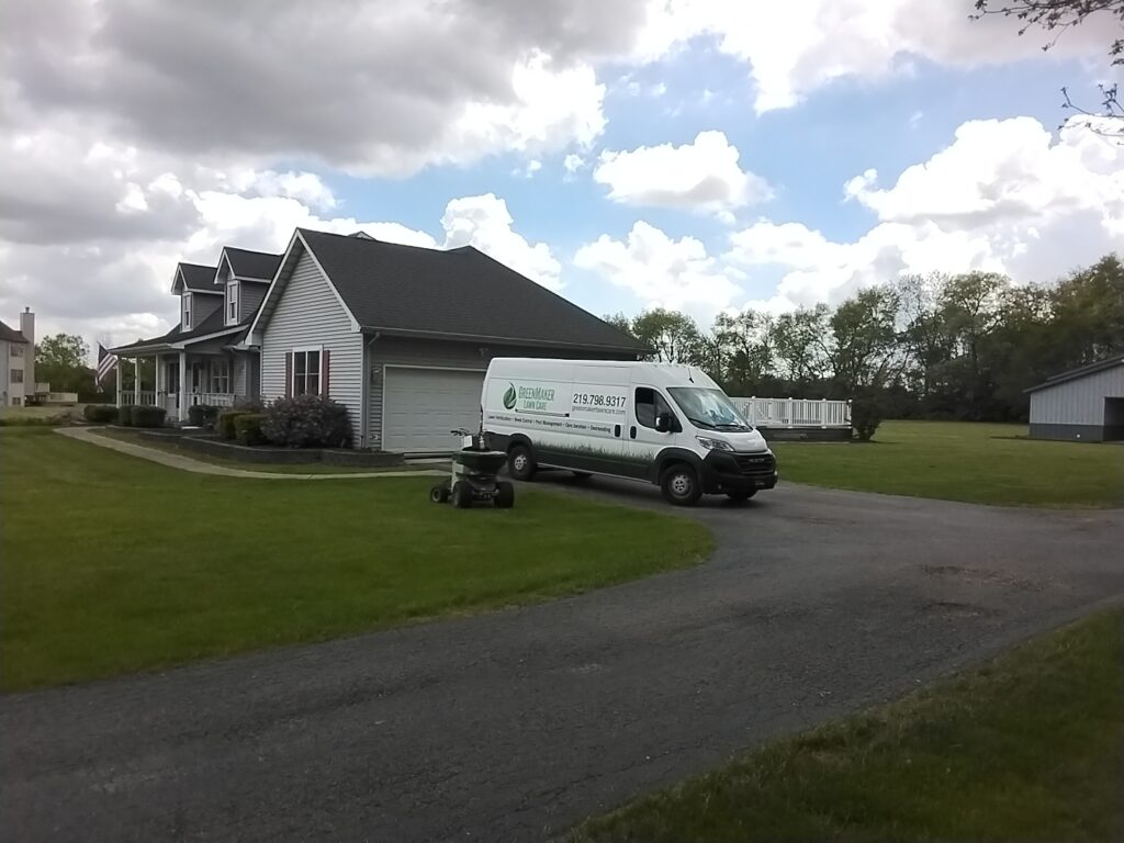 greenmaker van on driveway with spreader in front of house